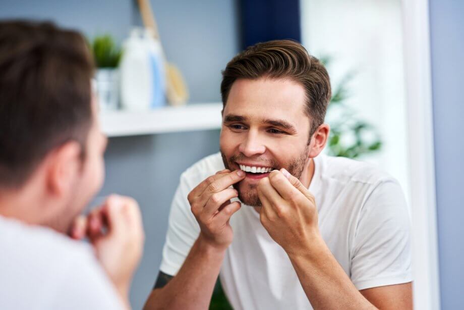 male flossing teeth